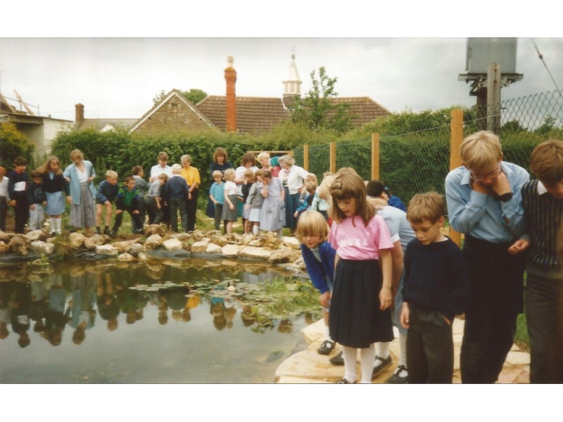 Children and Staff around the new pond in the school grounds